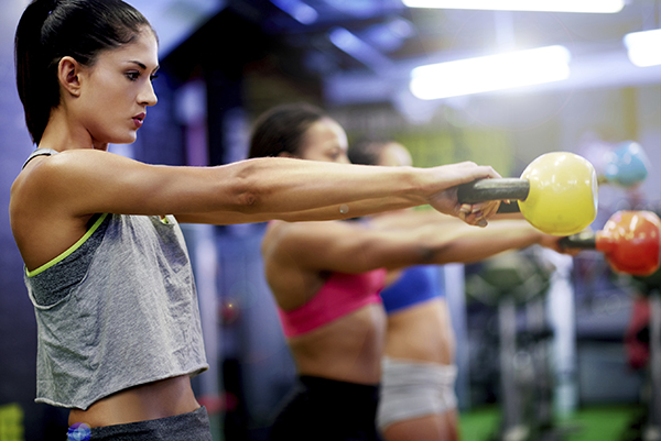 Women working out with kettlebells in a gym 