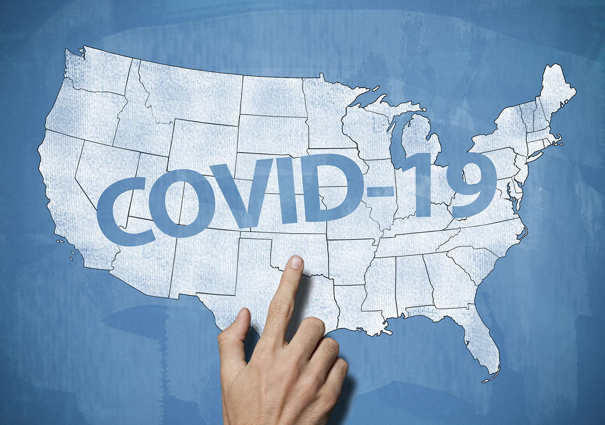 Illustration of US map with "COVID-19" written across the middle. A hand is coming up from the bottom of the frame pointing at the letters.