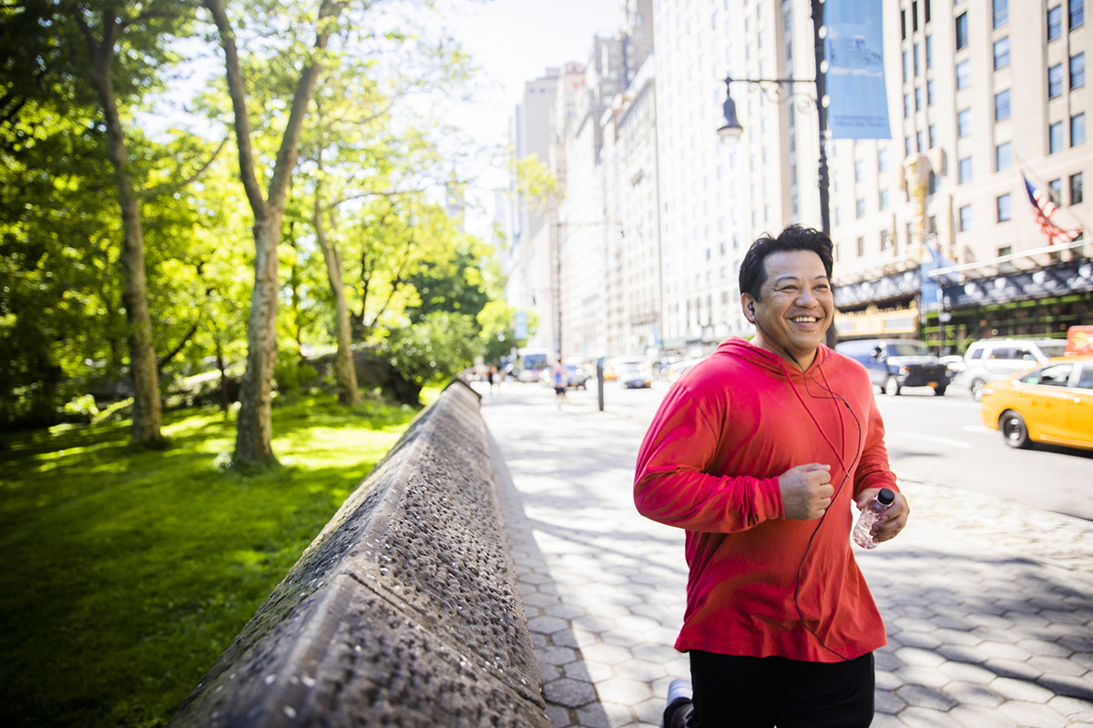 Man in red hoodie running near Central Park