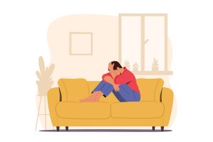 Illustration of depressed person on a yellow couch with their head in their hands