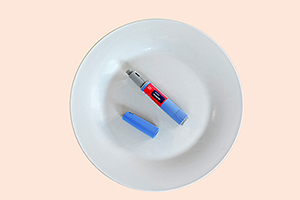 Semaglutide injecting pen with lid on a white plate