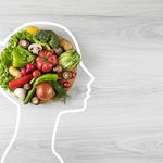 Healthy eating concept with vegetable and human head drawing on gray wooden background