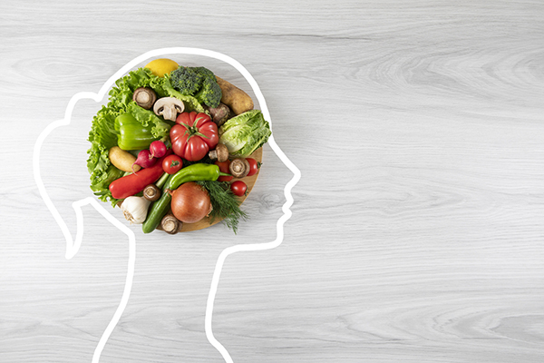 Healthy eating concept with vegetable and human head drawing on gray wooden background