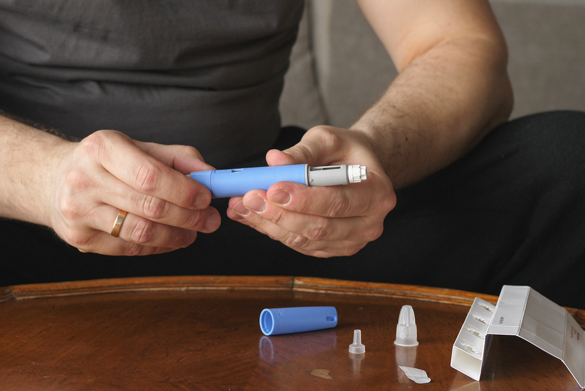 Heavy-set man preparing semaglutide injection
