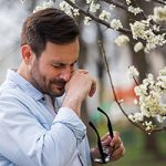 Man wiping nose because of pollen allergy in spring