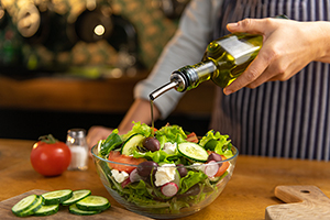 Pouring olive oil onto a salad