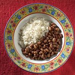 Rice and beans in a bowl with a colorful floral pattern around the rim.