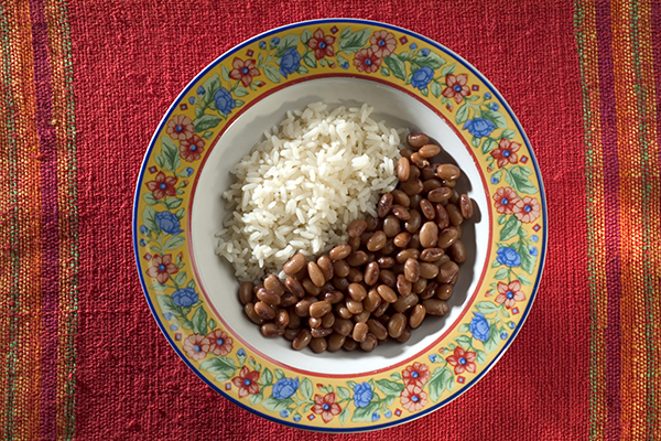 Rice and beans in a bowl with a colorful floral pattern around the rim.