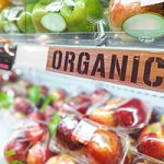 Organic food signage on modern supermarket fresh produce fruits aisle to appeal to healthy lifestyle shoppers