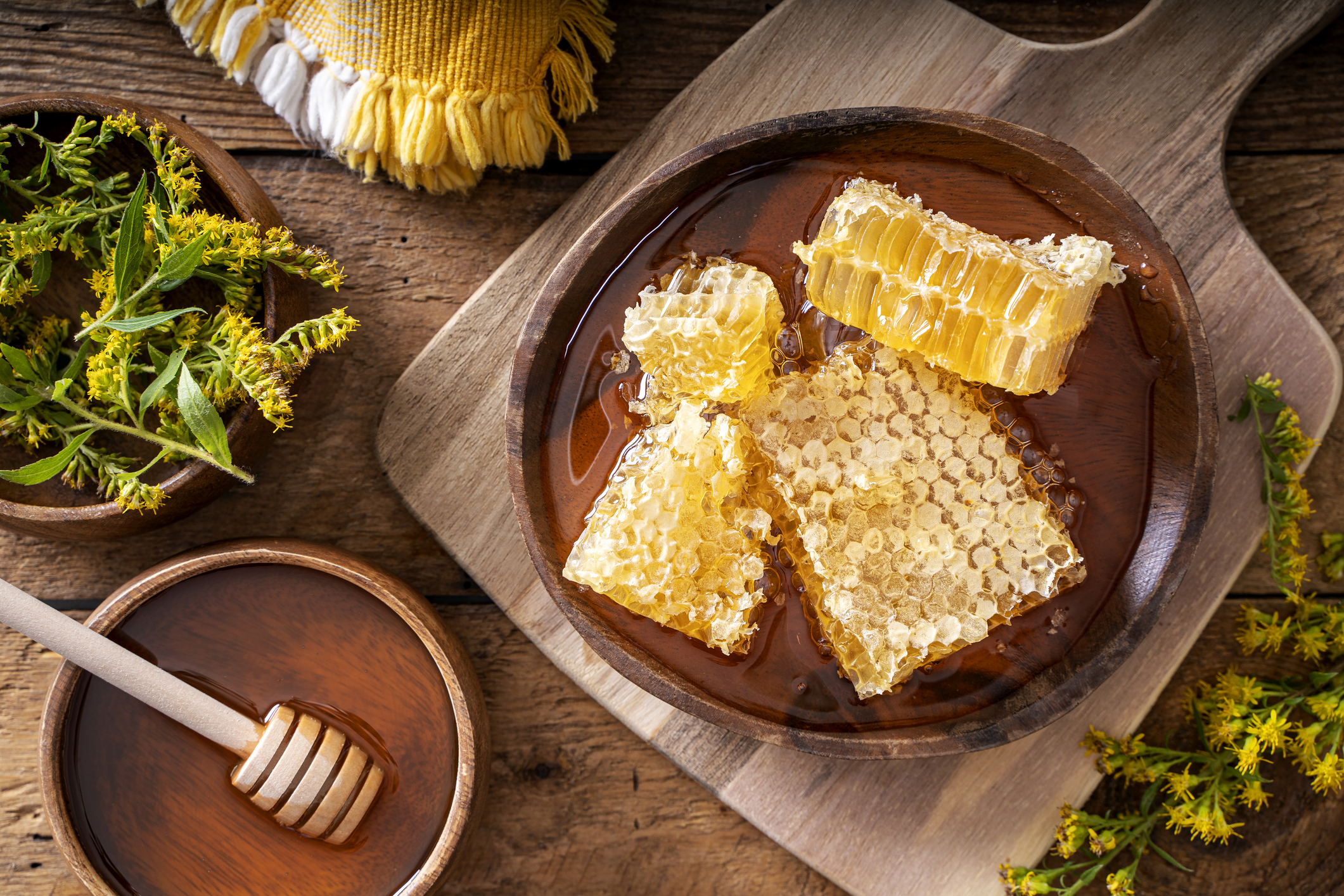 Raw natural honecomb on a rustic wood table top.