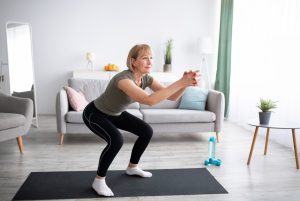 Woman doing squats in her living room