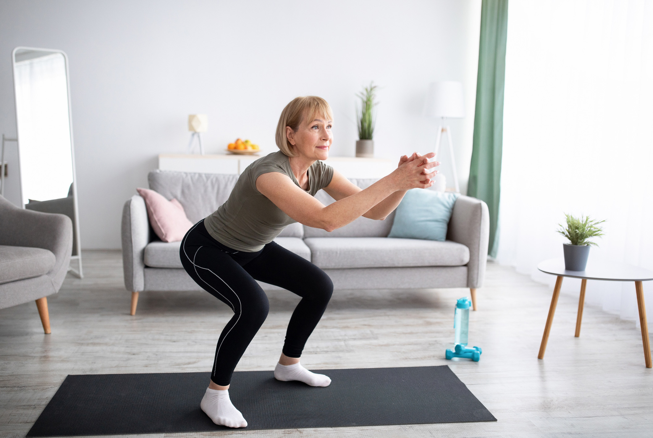Woman doing squats in her living room