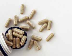 Top view of enzyme capsules spilling out a bottle