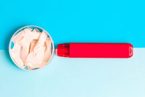 bowl full of nicotine pads next to an electronic cigarette