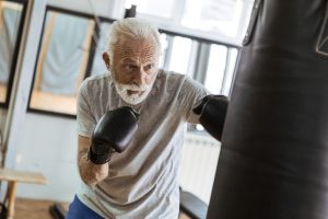 Senior man boxing in a training gym