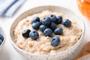 Oatmeal with blueberries in a stoneware bowl.