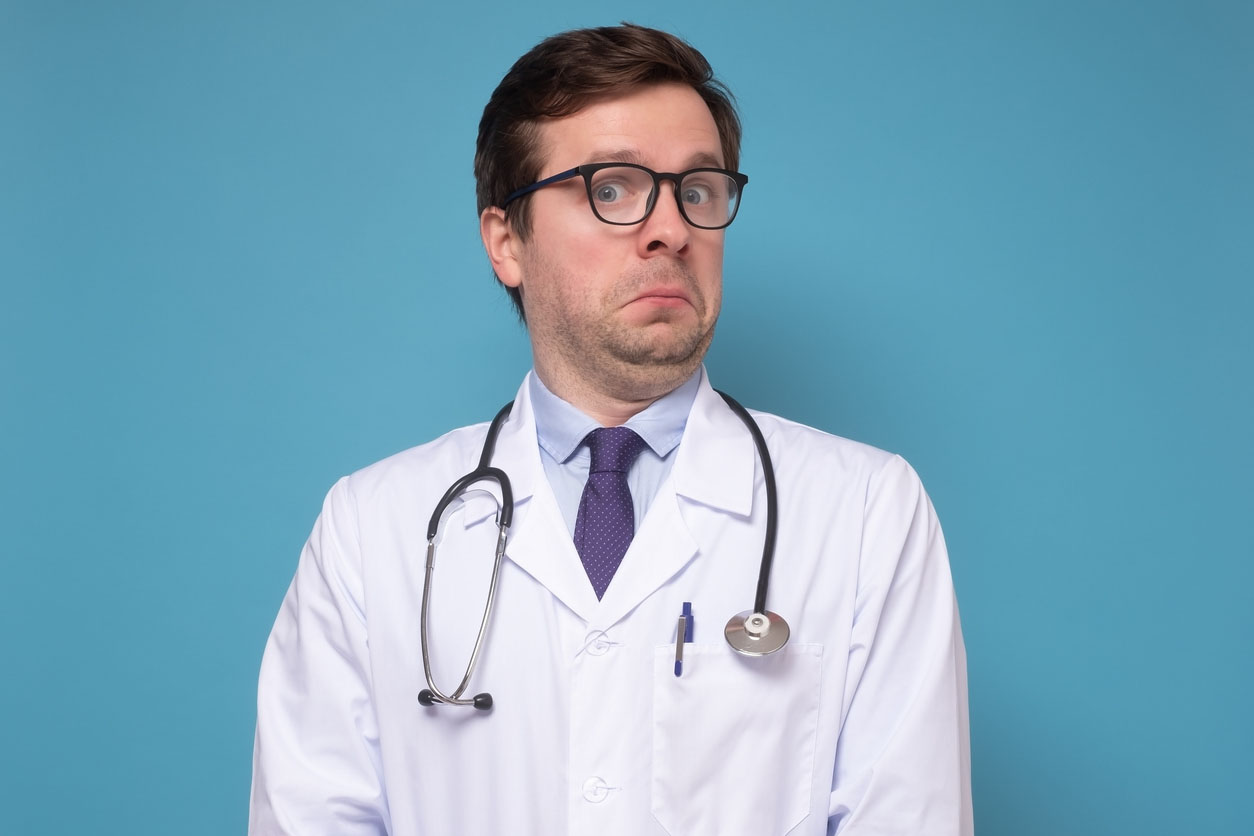 Puzzled caucasian male doctor with glasses and stethoscope is uncertain about procedure or diagnosis.
